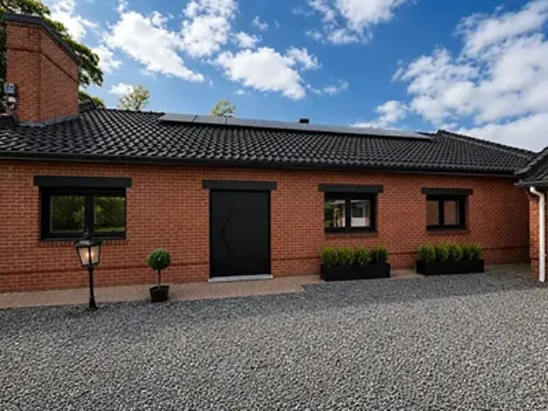 Châssis et porte d'entrée aluminium noirs posés sur une maison à La Louvière par AC Innov